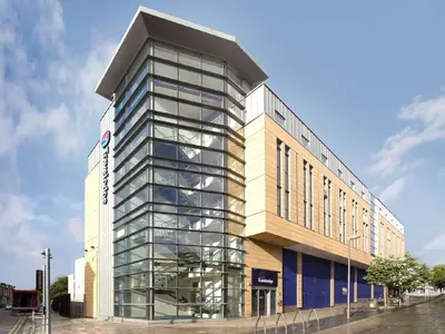 a tall building with a lot of glass at Travelodge Morecambe in Morecambe