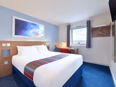 a hotel room with a large bed and a window at Travelodge Morecambe in Morecambe