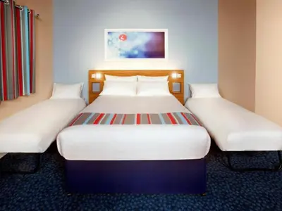 two beds in a hotel room with white beds at Travelodge Morecambe in Morecambe