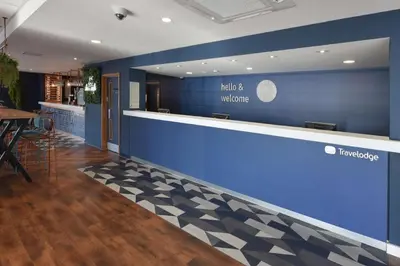a lobby of a hotel with a blue wall at Travelodge Blackpool South Shore in Blackpool
