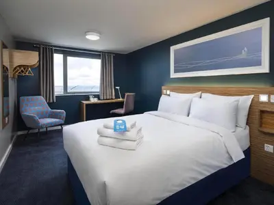 a bedroom with a large bed with towels on it at Travelodge Blackpool South Shore in Blackpool