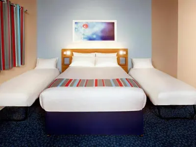 two beds in a hotel room with white beds at Travelodge Lytham St Annes in Saint Annes on the Sea