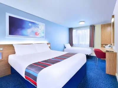 a hotel room with a large bed and a desk at Travelodge Lytham St Annes in Saint Annes on the Sea