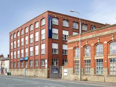 a brick building with a sign on the side of it at Travelodge Preston Central in Preston