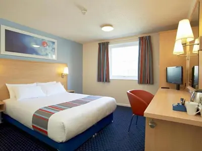 a hotel room with a bed and a desk at Travelodge Preston Central in Preston