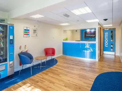 a waiting room with two chairs and a pool at Travelodge Burton M6 Northbound in Holme