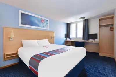 a hotel room with a large bed and a desk at Travelodge Burton M6 Northbound in Holme