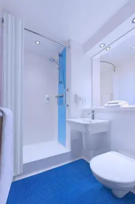 a white bathroom with a toilet and a sink at Travelodge Burton M6 Northbound in Holme