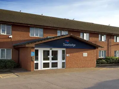 a red brick building with a sign on the door at Travelodge Barrow In Furness in Barrow in Furness