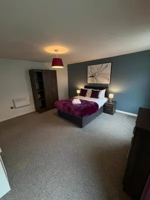 a bedroom with a bed with a purple bedspread at City Centre 4 Bedroom Apartment with Terrace Sleeps 10 by StaySavvy Accommodation in Liverpool