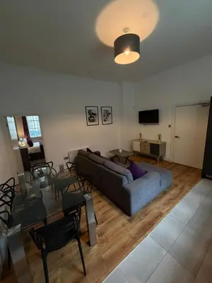 a living room with a couch and a table at City Centre 4 Bedroom Apartment with Terrace Sleeps 10 by StaySavvy Accommodation in Liverpool