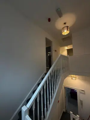 a hallway with a staircase with a white stair case at City Centre 4 Bedroom Apartment with Terrace Sleeps 10 by StaySavvy Accommodation in Liverpool
