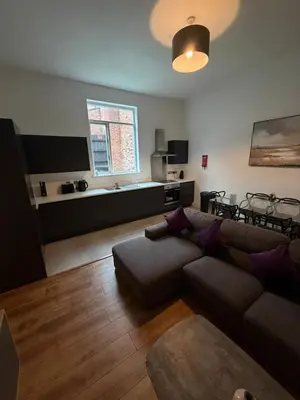a living room with a couch and a table at City Centre 4 Bedroom Apartment with Terrace Sleeps 10 by StaySavvy Accommodation in Liverpool