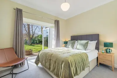 a bedroom with a bed and a chair and a window at The Royal Oak Barn Cartmel - Sleeps 4 in Cartmel