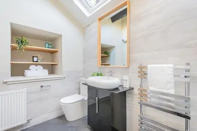 a bathroom with a sink and a toilet and a mirror at The Royal Oak Barn Cartmel - Sleeps 4 in Cartmel