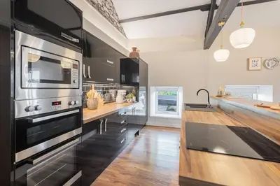a large kitchen with a stove and a counter at The Royal Oak Barn Cartmel - Sleeps 4 in Cartmel