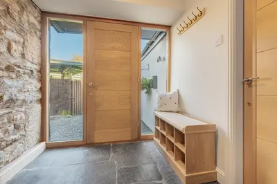 a hallway with a wooden door and a window at The Royal Oak Barn Cartmel - Sleeps 4 in Cartmel