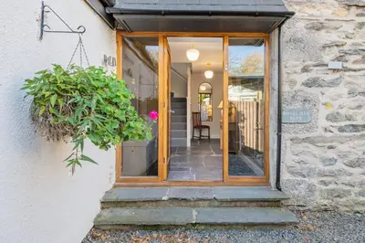 a door to a house with a potted plant at The Royal Oak Barn Cartmel - Sleeps 4 in Cartmel