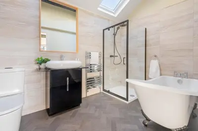 a bathroom with a tub and a sink and a shower at The Royal Oak Barn Cartmel - Sleeps 4 in Cartmel