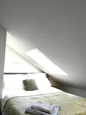 a bedroom with a white bed with a large window at Contractors House - 10 Seperate Beds - FREE Parking in Liverpool