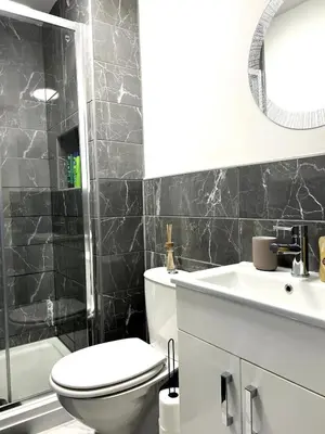 a bathroom with a toilet and a sink and a mirror at Contractors House - 10 Seperate Beds - FREE Parking in Liverpool