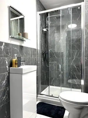 a bathroom with a shower and a toilet and a sink at Contractors House - 10 Seperate Beds - FREE Parking in Liverpool