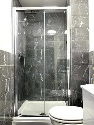 a bathroom with a shower and a toilet and a sink at Contractors House - 10 Seperate Beds - FREE Parking in Liverpool