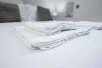a pile of white towels sitting on top of a table at Luxury Studio Apartment in Liverpool City Centre in Liverpool