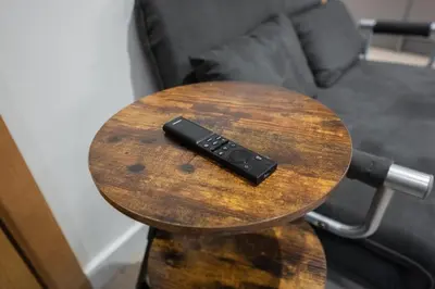 a remote control sitting on top of a wooden table at Luxury Studio Apartment in Liverpool City Centre in Liverpool