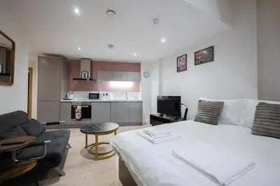 a bedroom with a bed and a living room at Luxury Studio Apartment in Liverpool City Centre in Liverpool