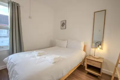 a white bed in a room with a mirror at Charming & Relaxing Getaway near Liverpool City in Liverpool