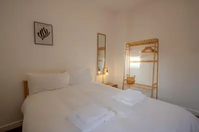 a white bed with two towels on top of it at Charming & Relaxing Getaway near Liverpool City in Liverpool
