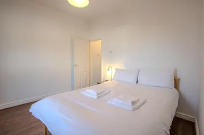 a white bed with two towels on top of it at Charming & Relaxing Getaway near Liverpool City in Liverpool