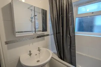 a bathroom with a sink and a mirror and a window at Charming & Relaxing Getaway near Liverpool City in Liverpool