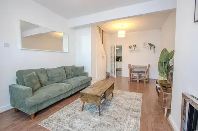 a living room with a green couch and a table at Charming & Relaxing Getaway near Liverpool City in Liverpool