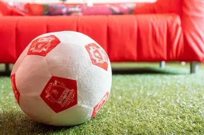 a red and white soccer ball sitting on the grass at The Red One-Sleeps 16, near Anfield & City Centre in Liverpool