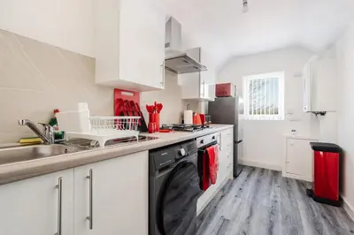 a kitchen with a sink and a dishwasher at The Red One-Sleeps 16, near Anfield & City Centre in Liverpool
