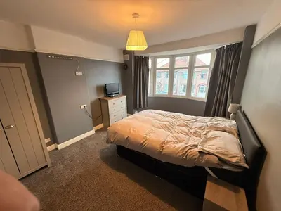 a bedroom with a bed and a television and a window at Sanders Grove in Morecambe