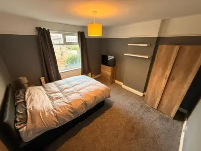 a bedroom with a bed and a window at Sanders Grove in Morecambe