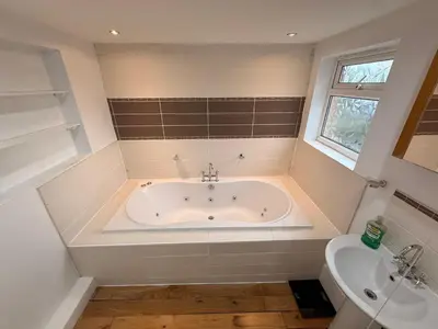 a bathroom with a bath tub and a sink at Sanders Grove in Morecambe