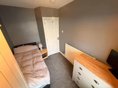 a small bedroom with a bed and a dresser at Sanders Grove in Morecambe