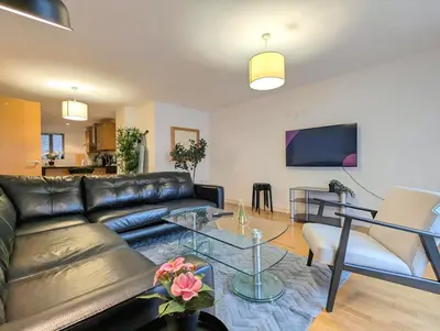 a living room with a leather couch and a table at Spacious 2-Bedroom Apt in Heart of City Centre in Liverpool