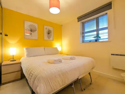 a bedroom with a bed with two towels on it at Spacious 2-Bedroom Apt in Heart of City Centre in Liverpool