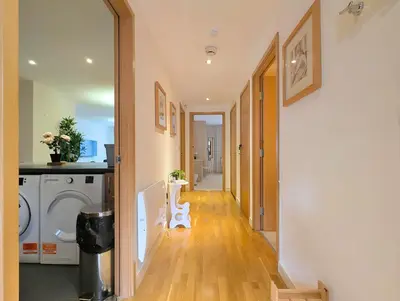 a hallway of a home with a washing machine at Spacious 2-Bedroom Apt in Heart of City Centre in Liverpool