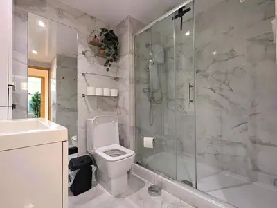 a bathroom with a shower and a toilet and a sink at Spacious 2-Bedroom Apt in Heart of City Centre in Liverpool