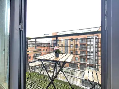 a table on a balcony with a view of a building at Spacious 2-Bedroom Apt in Heart of City Centre in Liverpool