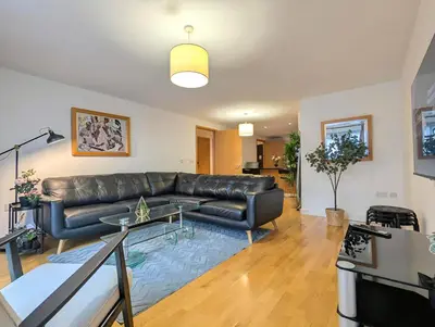 a living room with a leather couch and a table at Spacious 2-Bedroom Apt in Heart of City Centre in Liverpool
