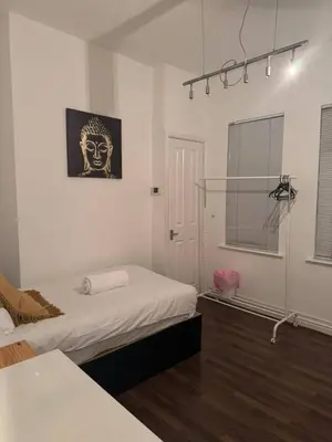 a bedroom with a bed and a picture of a mask at The Fabulous Gem in Wallasey in Wallasey