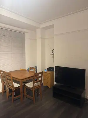a dining room with a wooden table and a flat screen tv at The Fabulous Gem in Wallasey in Wallasey