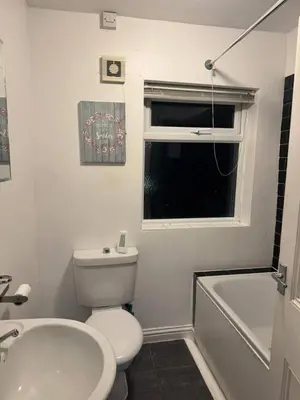 a bathroom with a toilet and a sink and a window at The Fabulous Gem in Wallasey in Wallasey